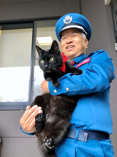 3月14日，黑猫“ken”与警卫大叔。（图片来源：朝日新闻网站）