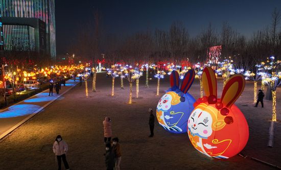 在滨河公园的步行道上，布满了充满年味的灯光装饰，市民和游客们边赏灯边拍照打卡，在霓虹的灯光中流连忘返，感受春节喜庆的氛围。