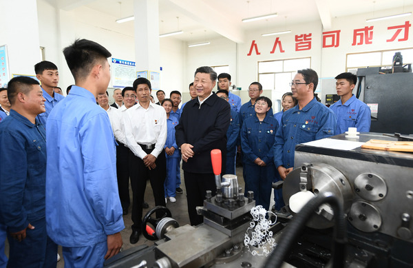 2019年8月20日，习近平在甘肃省张掖市山丹培黎学校现代制造技术实训室，观看职业技能实训，同师生亲切交流。