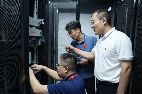 麒麟软件有限公司机房内，孔金珠（右一）和同事在一起工作。    麒麟软件有限公司供图